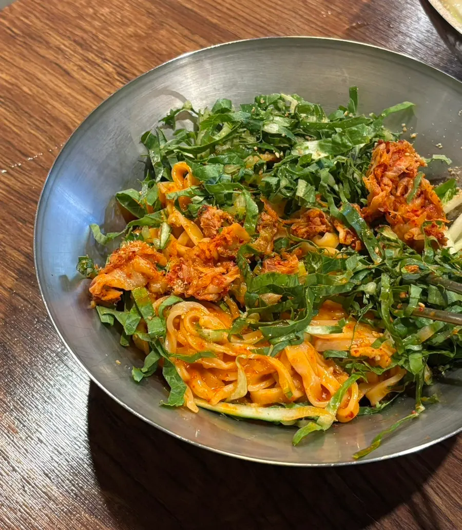 Bibim kalguksu noodles mixed with kimchi and meat toppings