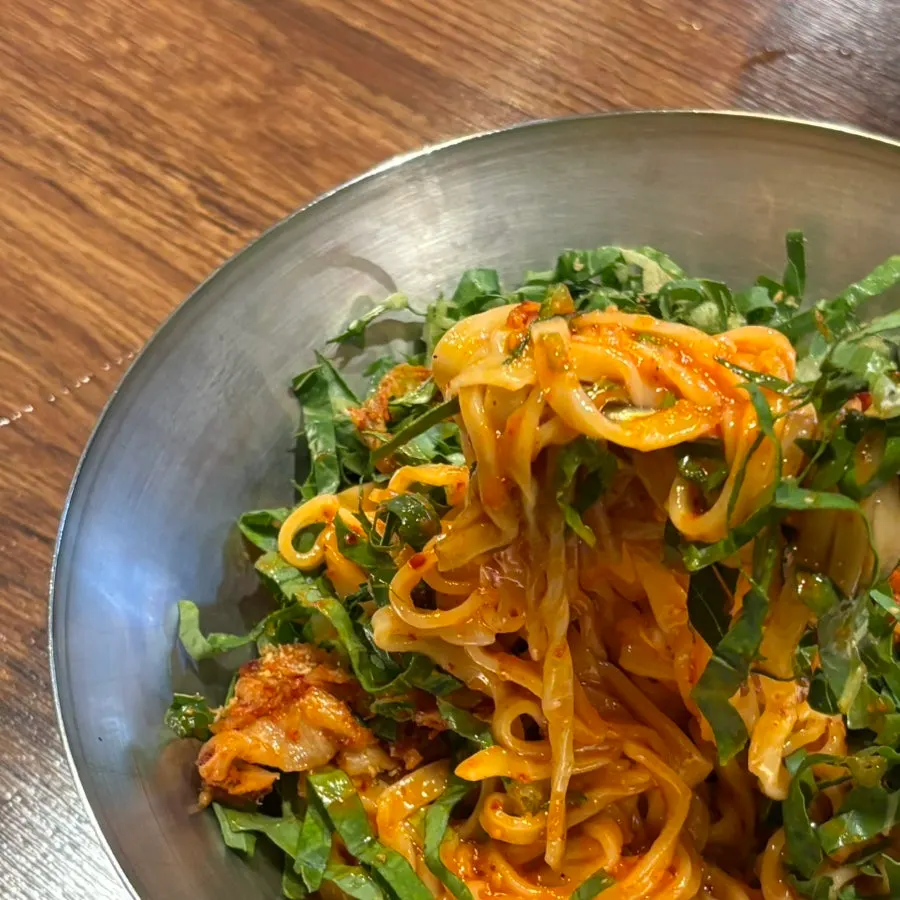 Handmade bibim kalguksu noodles lifted with chopsticks