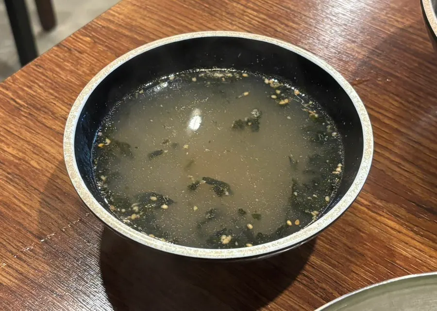 Warm broth served alongside the bibim kalguksu