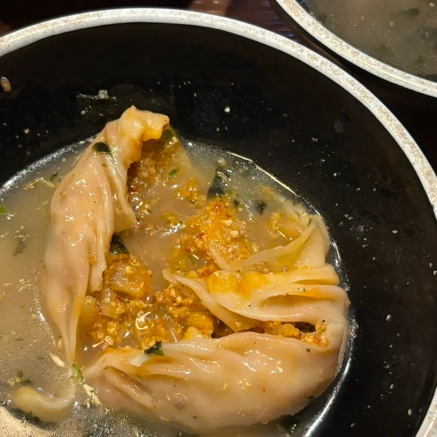 A handmade dumpling lifted on a spoon
