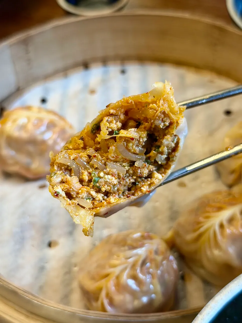 A table set with dumpling kalguksu soup and steamed dumplings