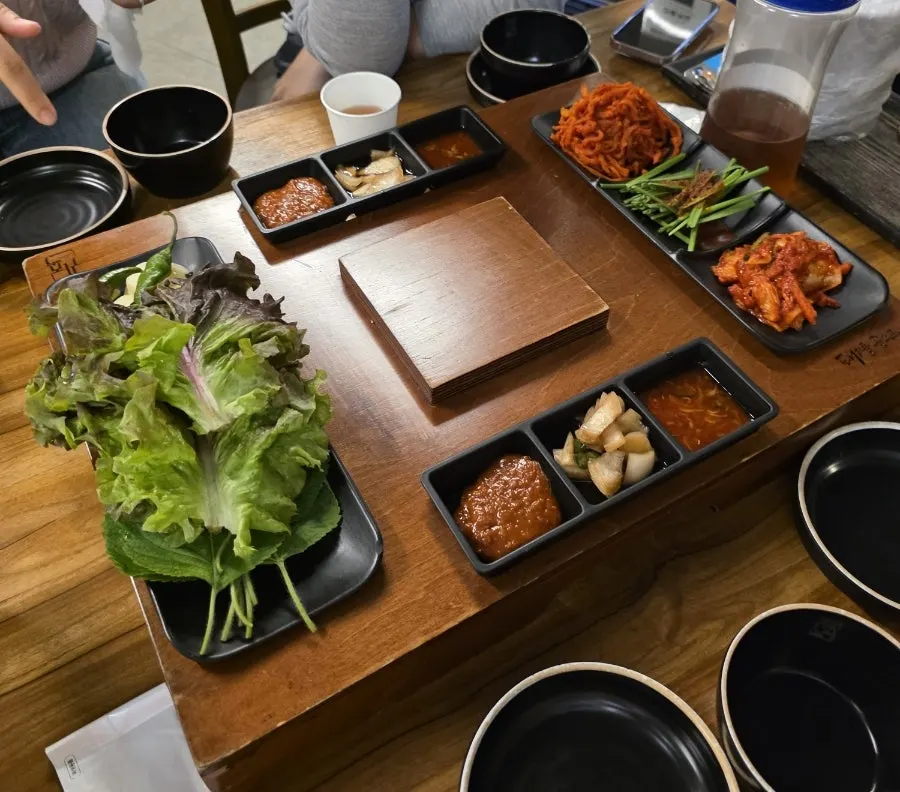 Basic side dishes including wrap vegetables, dried radish strips, and fresh kimchi