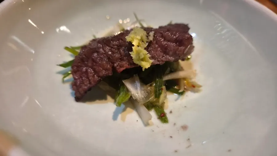 Meat covered with a stainless steel cup to add charcoal aroma