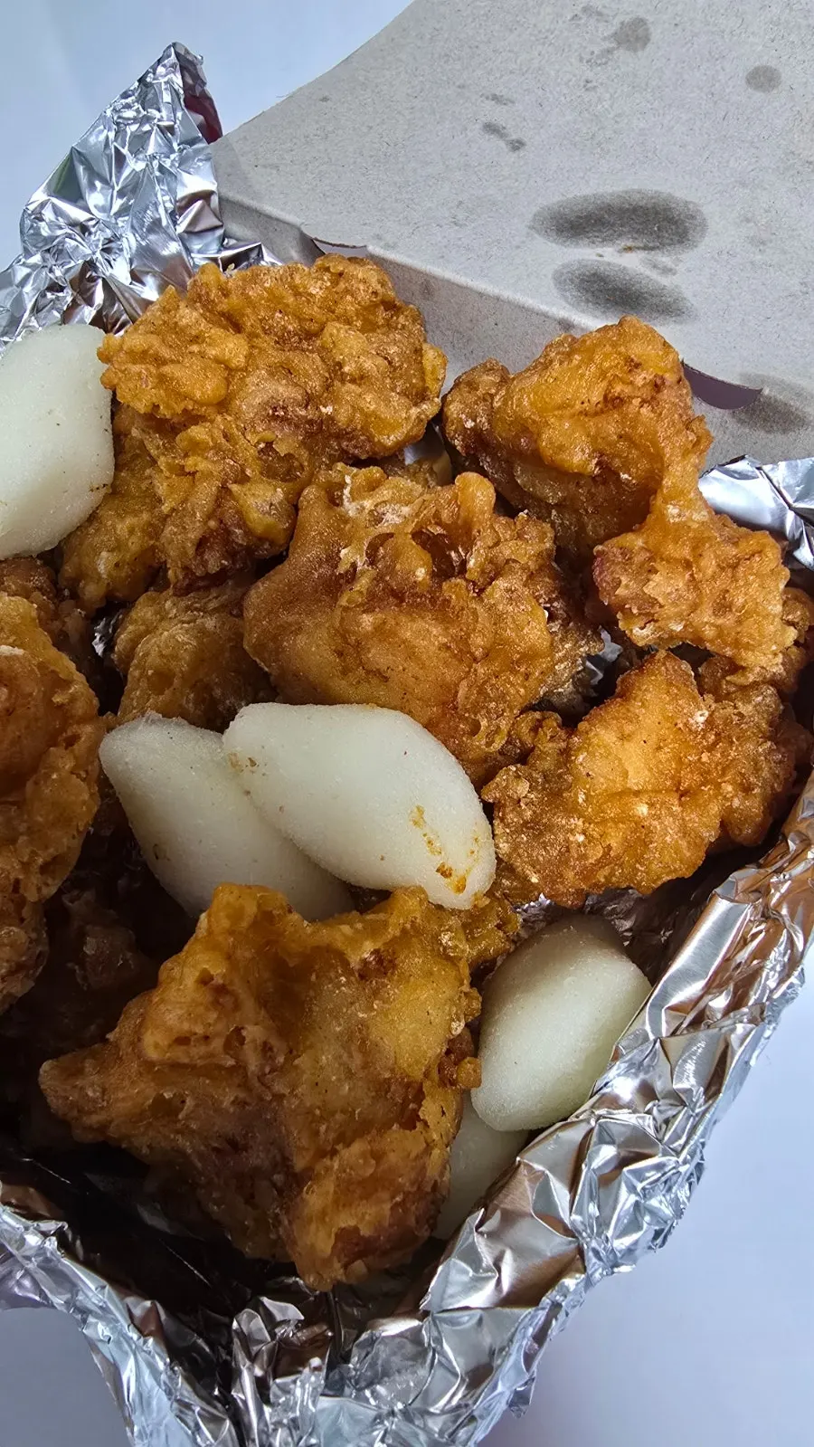 Fried dakgangjeong picked up with a skewer