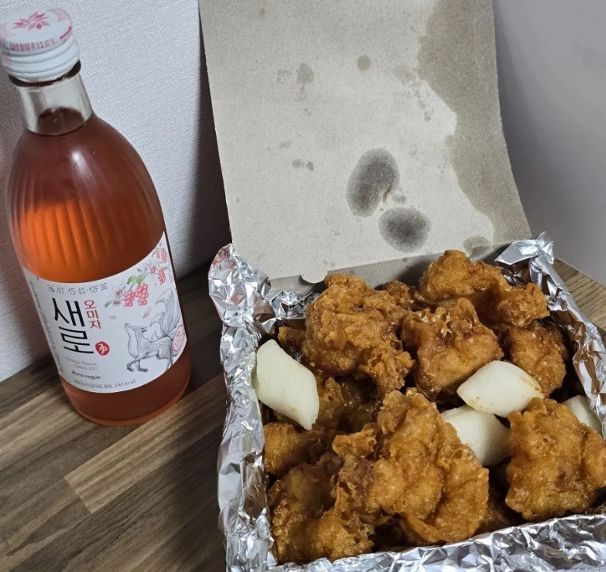 A plate of dakgangjeong served with fried rice cake skewers
