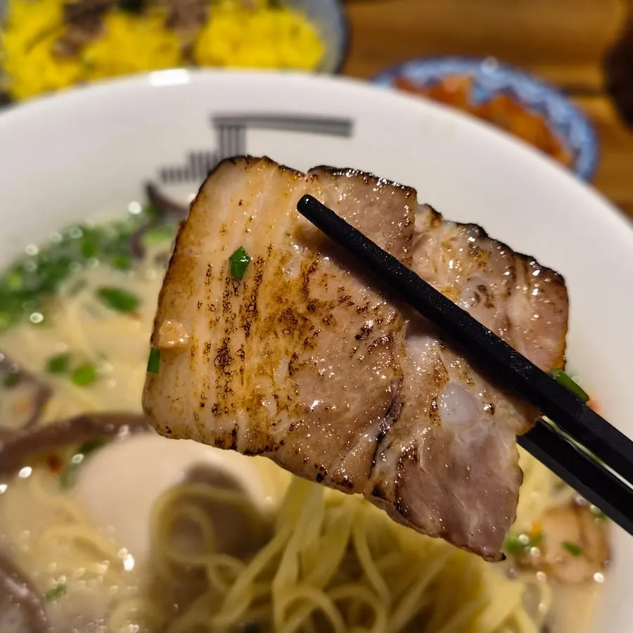 Thin straight ramen noodles lifted with chopsticks
