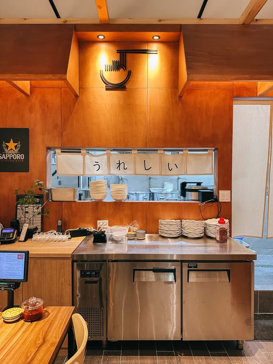 Open kitchen with the word 'ureshii' and wood-tone interior