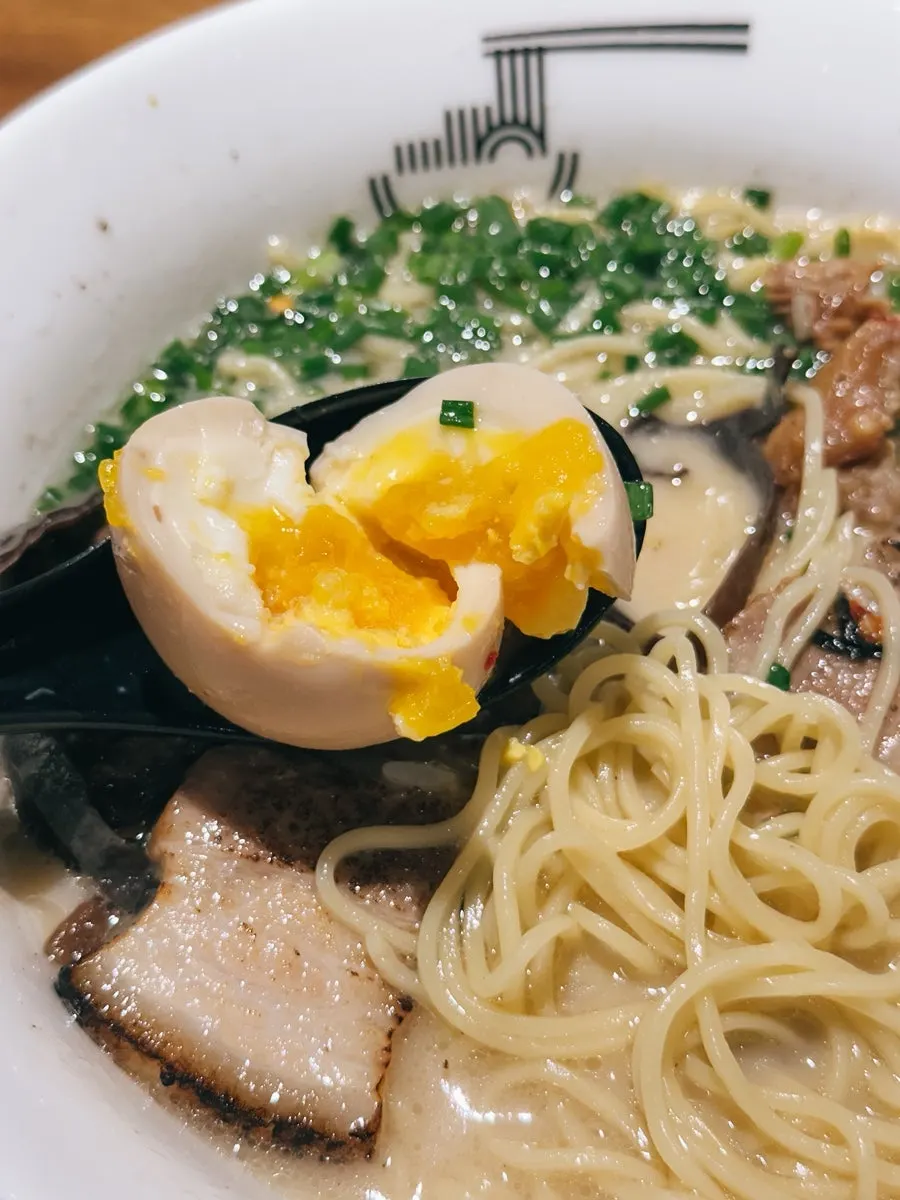 Soft-boiled egg stirred into the broth