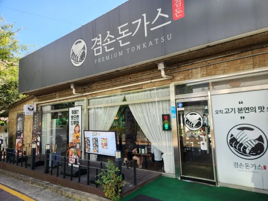 Entrance to Gyeomson Donkatsu Geomdan Branch across from the apartment complex