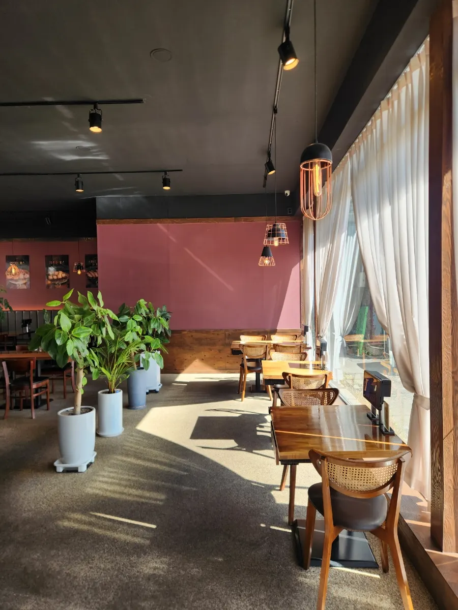 Interior of Gyeomson Donkatsu Geomdan Branch filled with sunlight from floor-to-ceiling windows
