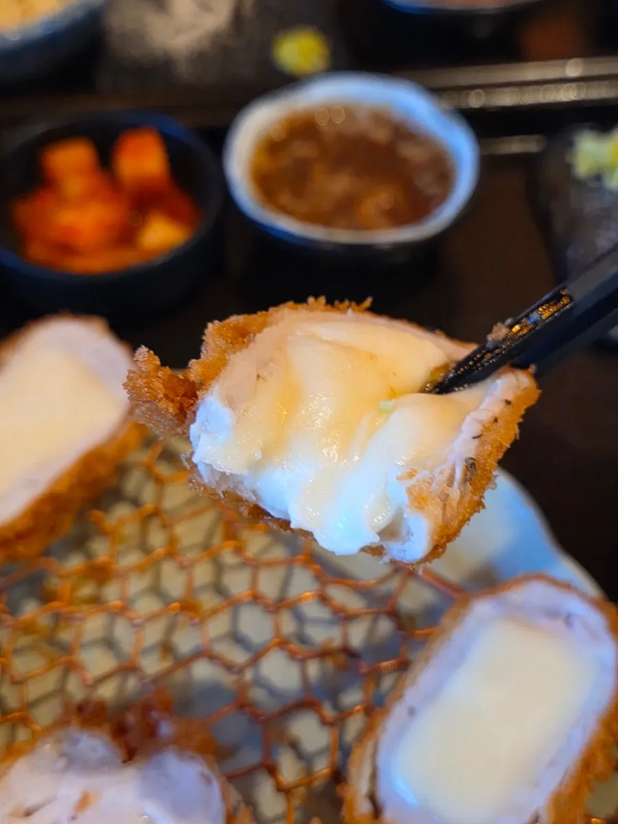 わさびをのせて食べるチーズかつの一切れ