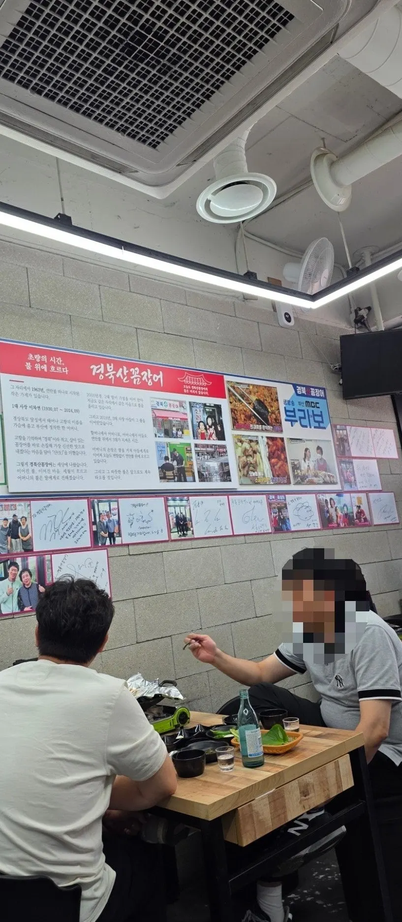 Wall covered in celebrity signatures below the menu board