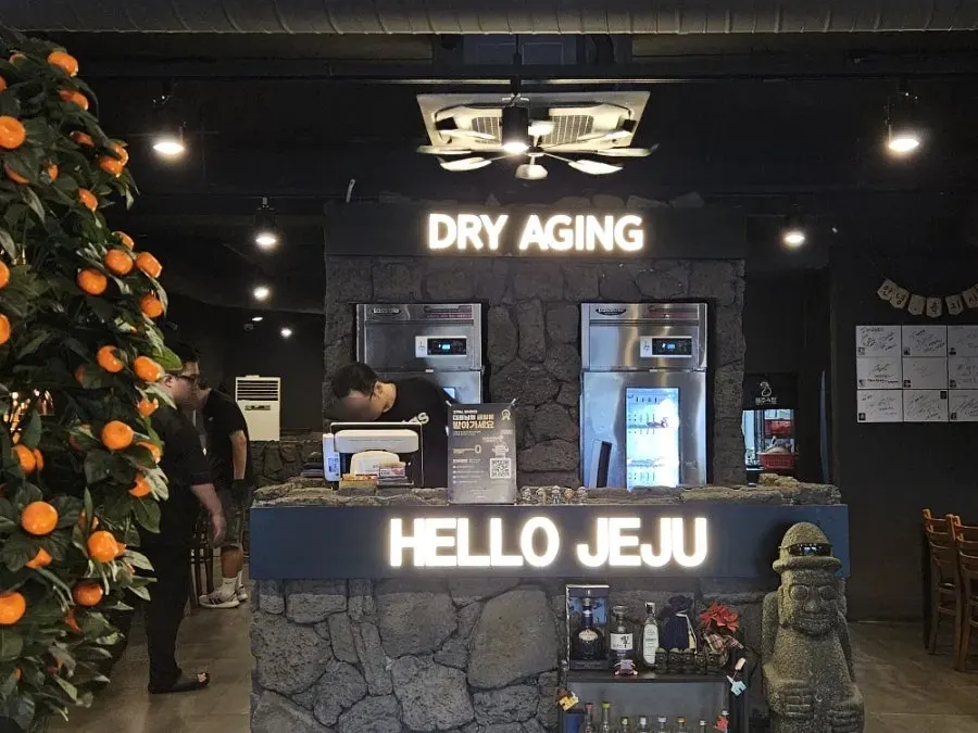 Jeju Oktop entrance decorated with dol hareubang statues and hallabong tangerines