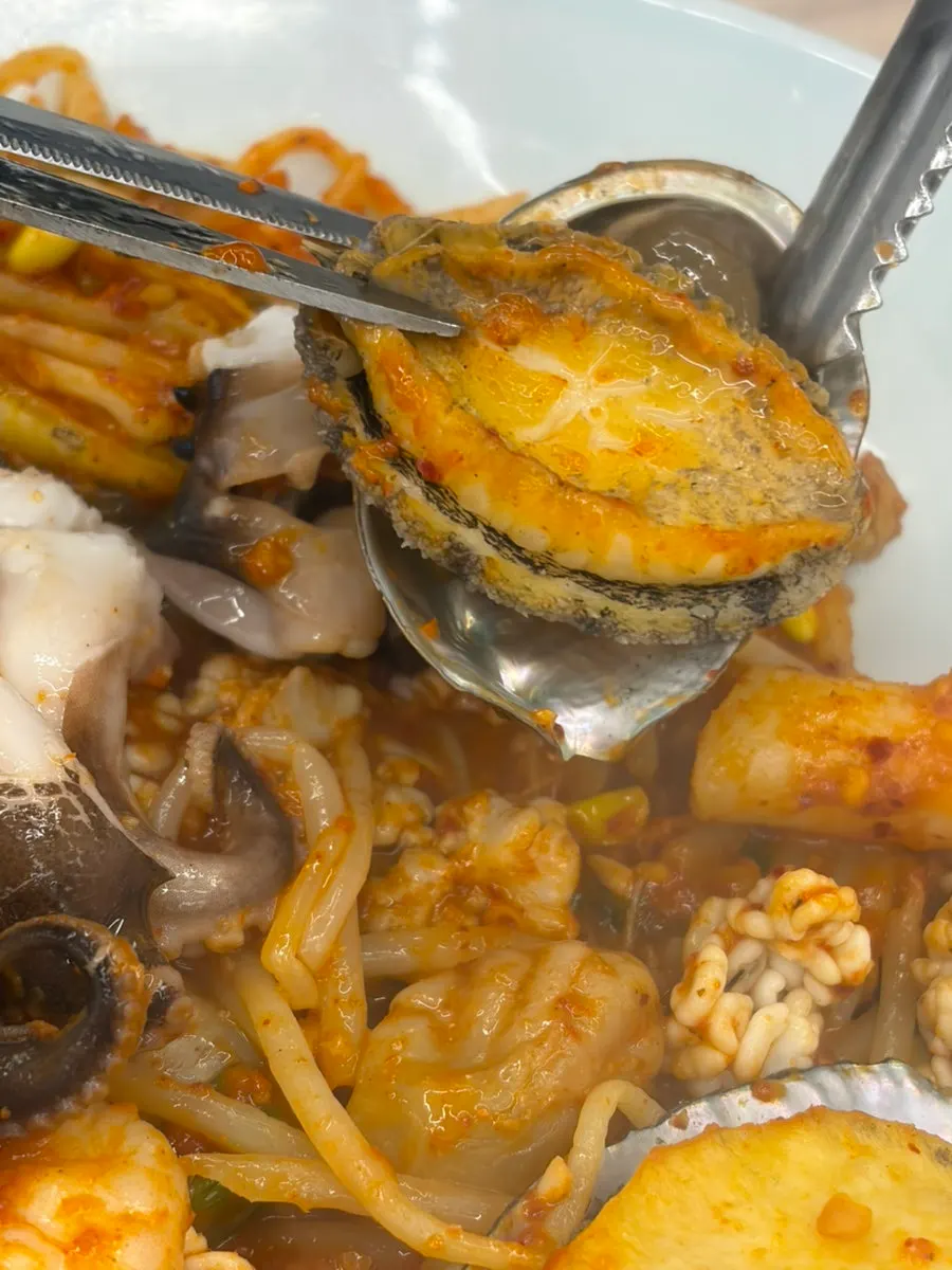 A hefty piece of octopus on top of the abalone seafood stew