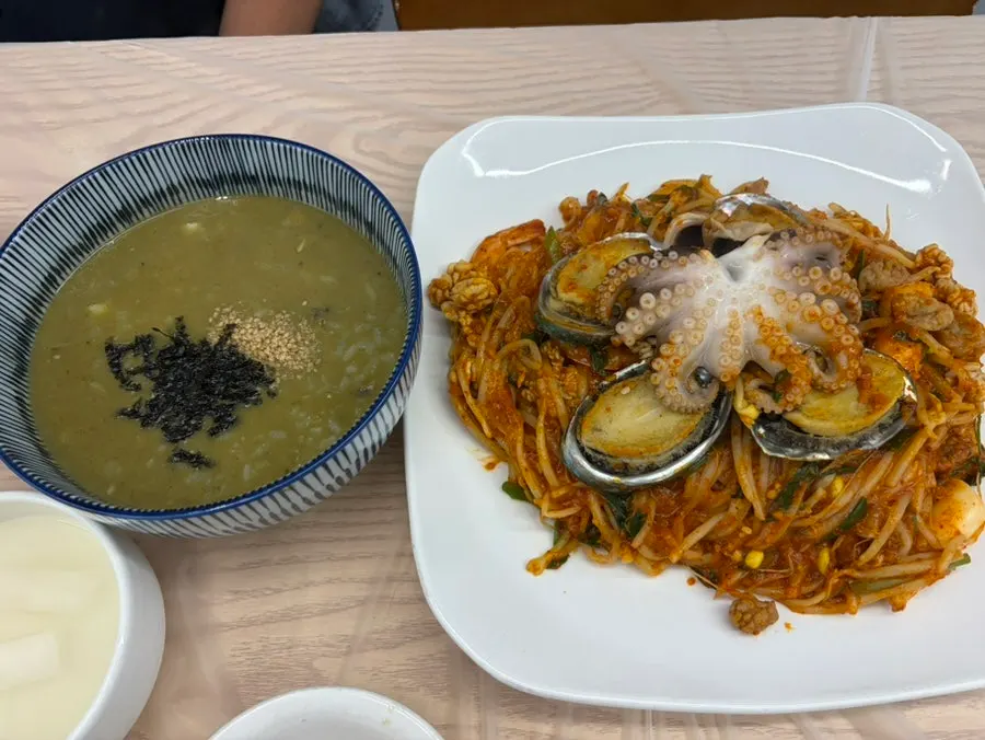 Full table setting with abalone seafood stew and abalone porridge
