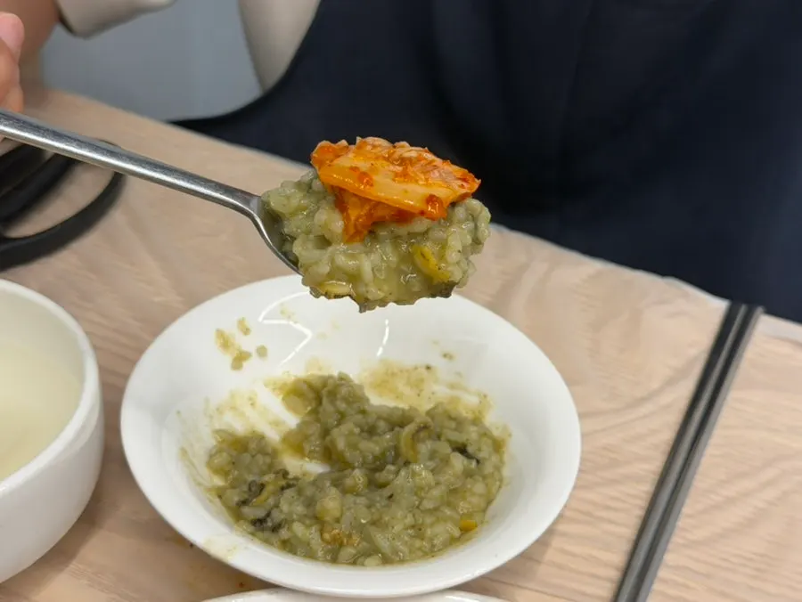 전복죽 위에 올린 김치 한 점