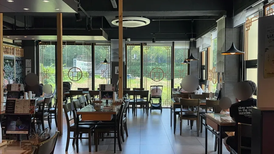 Sunlit interior of Hyoeunok through floor-to-ceiling windows