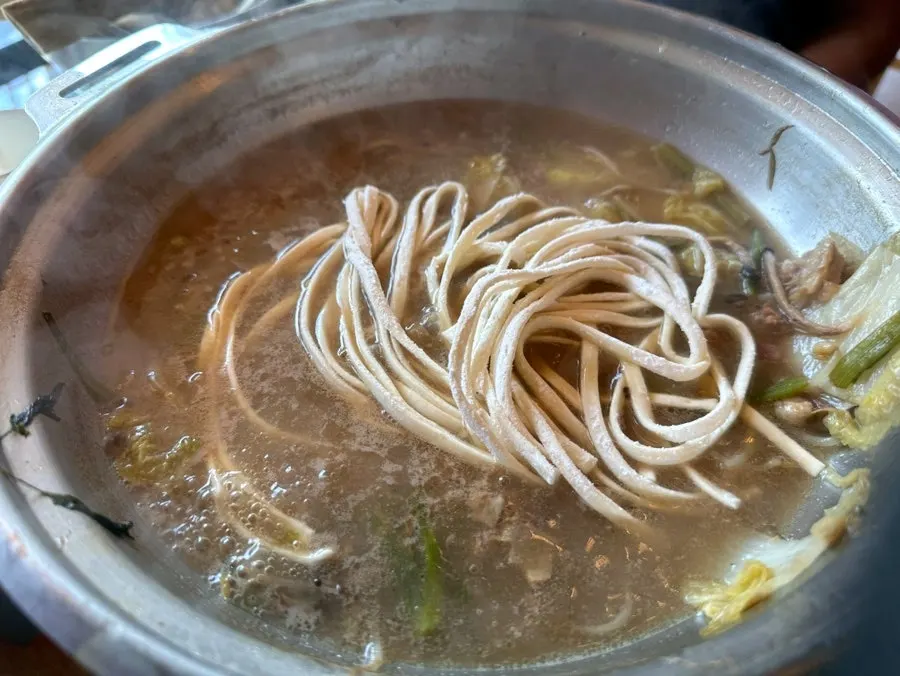 Noodle strands soaked in rich beef bone broth