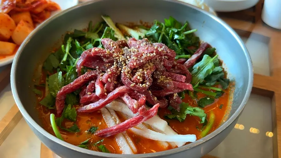 Raw beef and minari topping the cold hoetjguk soup