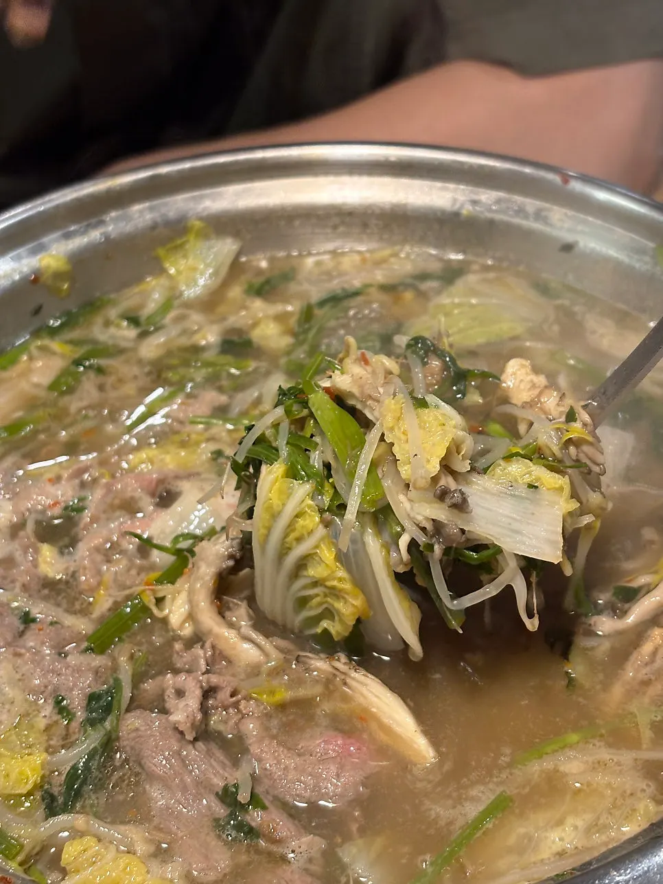 The beef bone hot pot broth and vegetables simmering