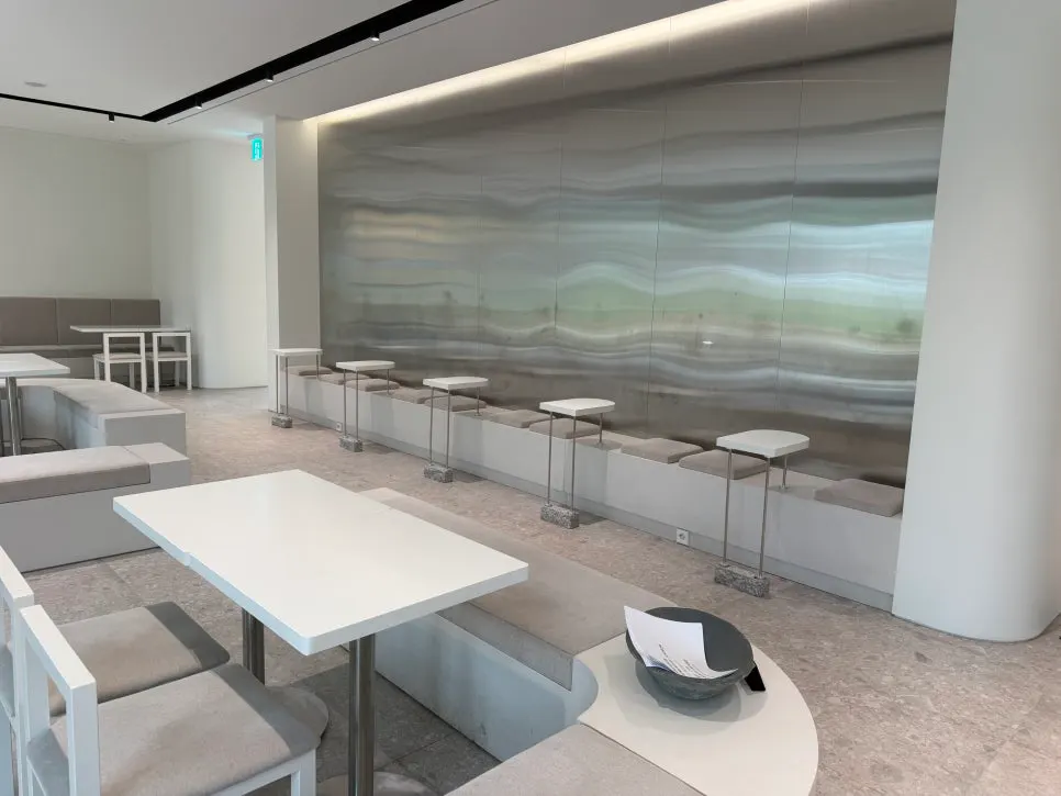 Painting on the wall and gray cushioned bench seating