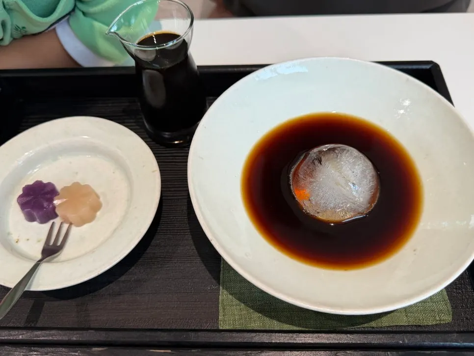 Dawan coffee in a white-porcelain-colored bowl with a large ice chunk