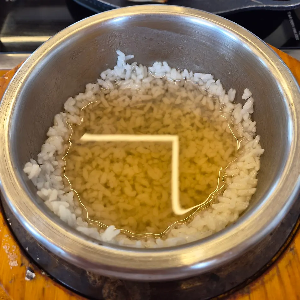 Eel being piled onto the hot pot rice