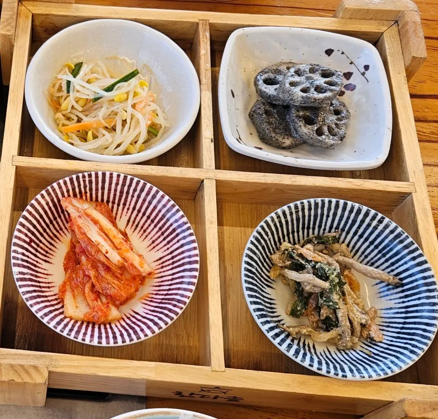 Neatly prepared side dishes served with stone-pot rice