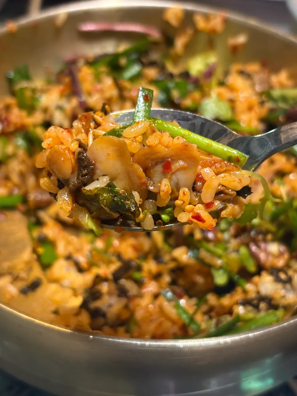 A spoonful of kkomak bibimbap mixed with gochujang seasoning