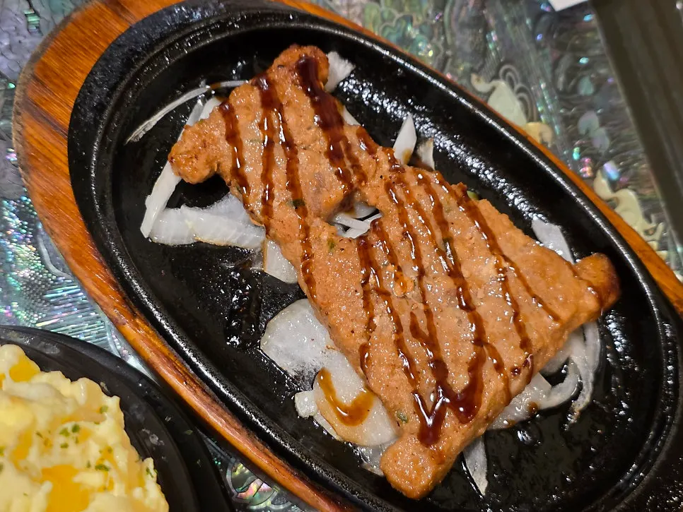 Plate surrounded by Korean beef tartare, charcoal bulgogi, and charcoal chicken skewers