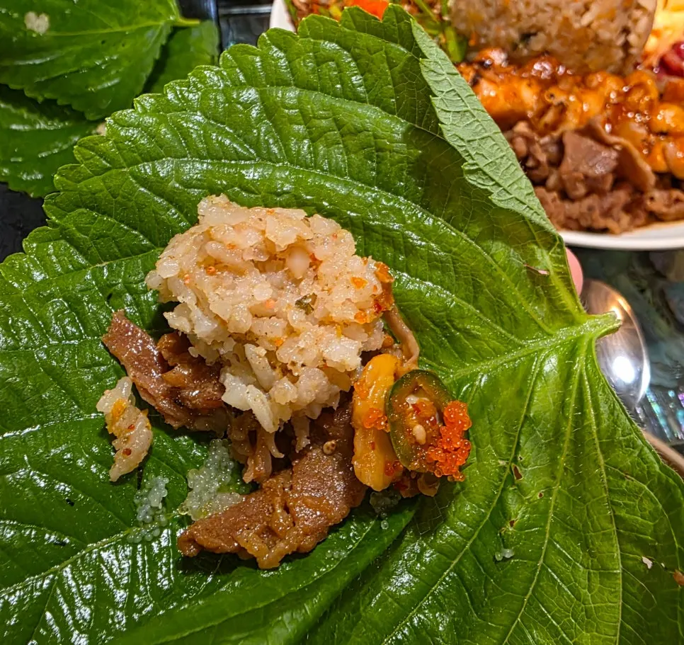 A single bite of flying fish roe perilla wrap