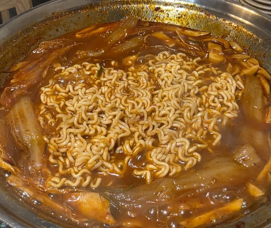 Ramen noodle add-in placed into the rib stew broth