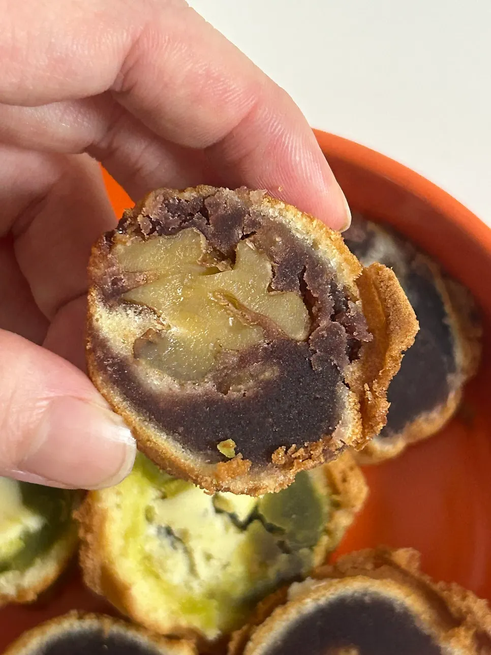 A bitten walnut pastry showing the filling inside