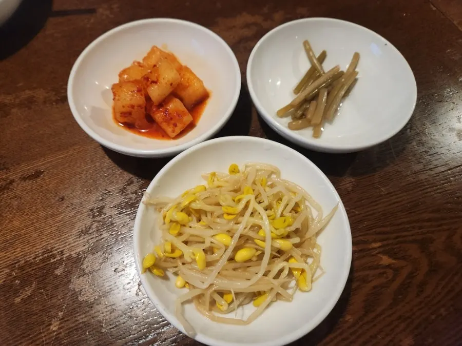 Mix-in bowl with seaweed flakes, sesame oil, bean sprouts and diced radish kimchi sides
