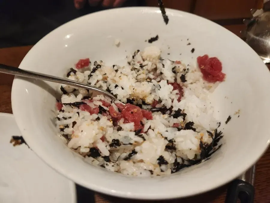 A bowl of beef tartare rice being mixed