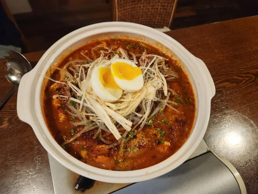 A pot of sumi dakbokkeumtang topped with soft-boiled egg