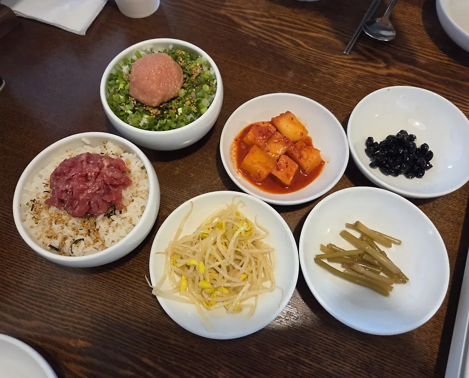 Table setting with four side dishes plus beef tartare and pollack roe rice