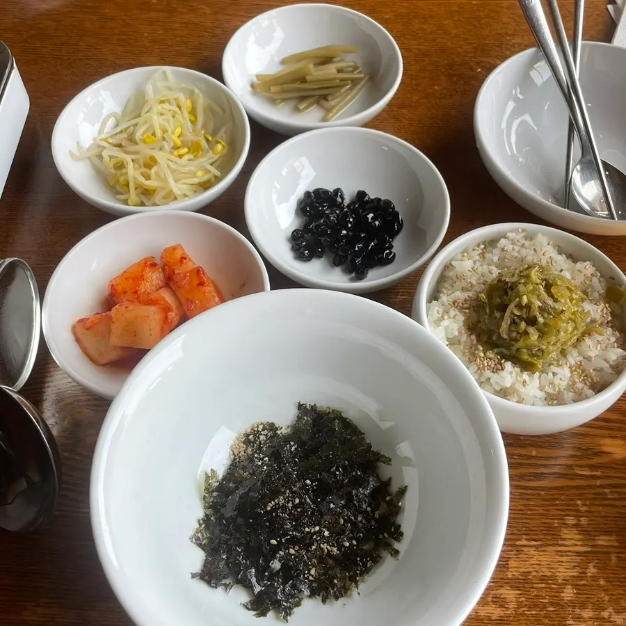 Table set with basic side dishes like radish kimchi and bean sprouts