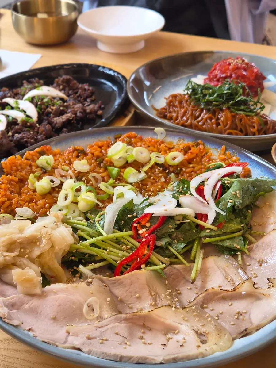 A wrap of cold jeyuk topped with fried rice and herring roe jeotgal