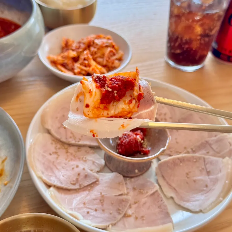 냉제육 한 점을 집어 든 모습
