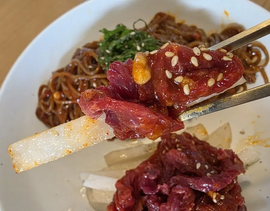 Hanwoo yukhoe and pear topped on the buckwheat noodles