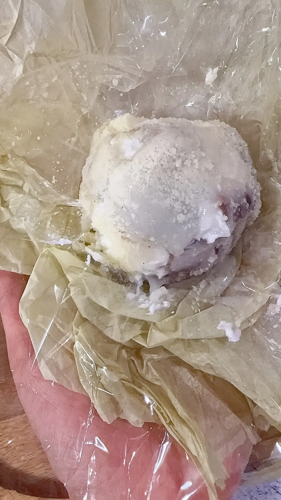 A double-wrapped mochi with a bite taken out