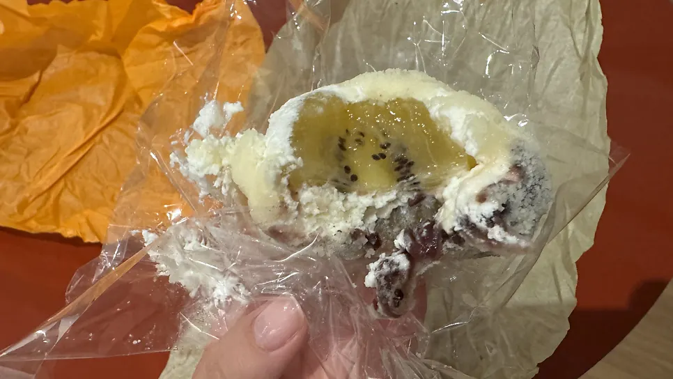 Cross-section of gold kiwi mochi with red bean inside
