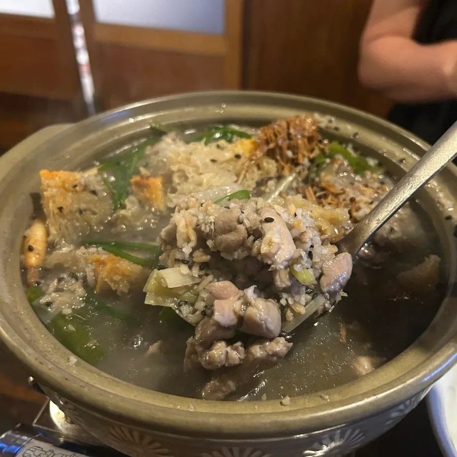 Boiling chicken stew with black sesame and nurungji risen to the top