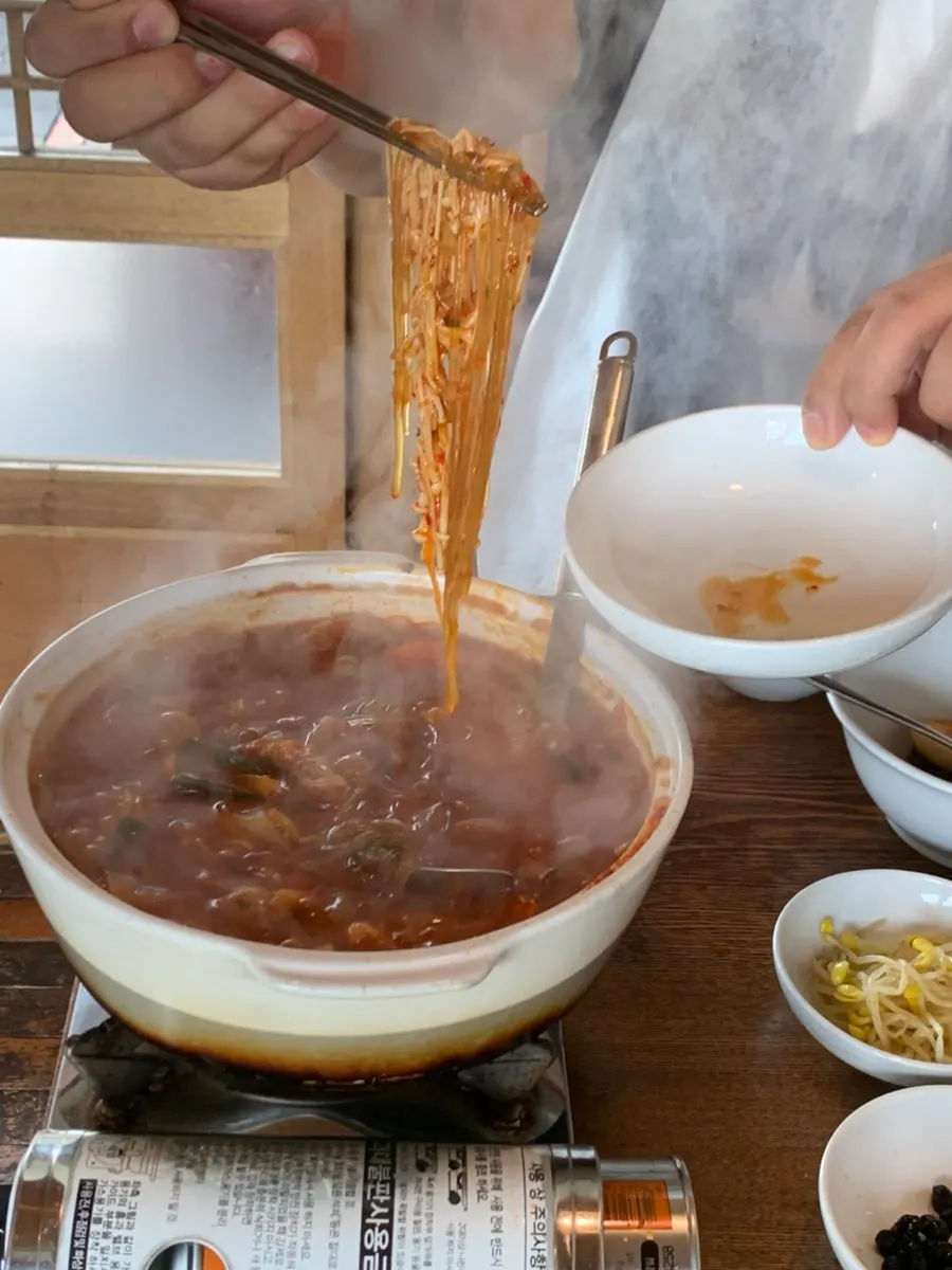 Lifting out glass noodles soaked in broth