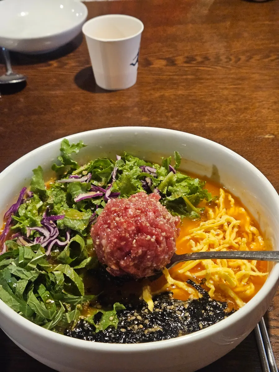 Beef mulhoe topped with yukhoe, vegetables, and egg garnish