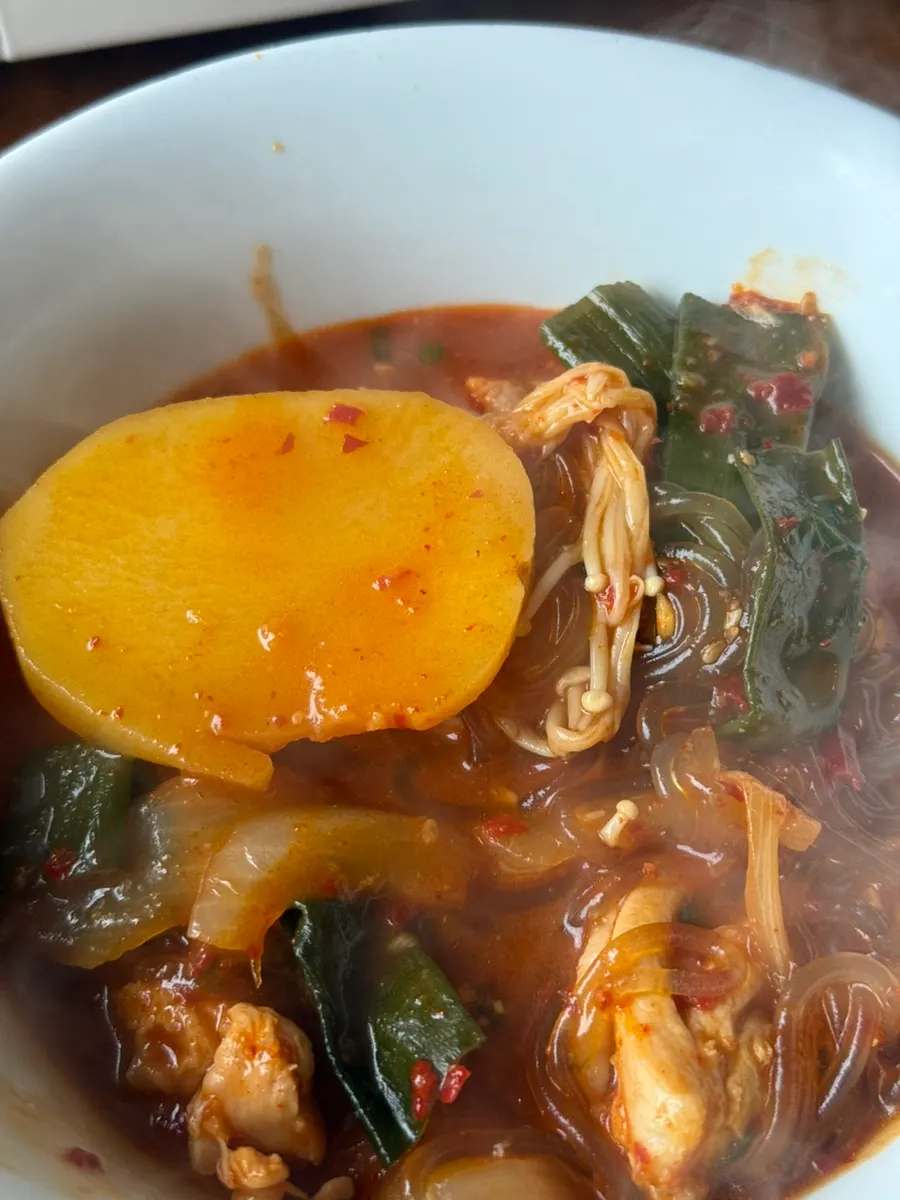 Pouring chicken stew broth into a plate of seaweed flakes