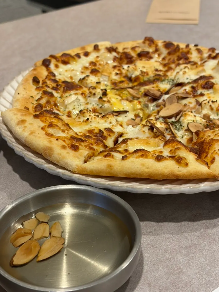 A slice of quattro cheese pizza served with honey