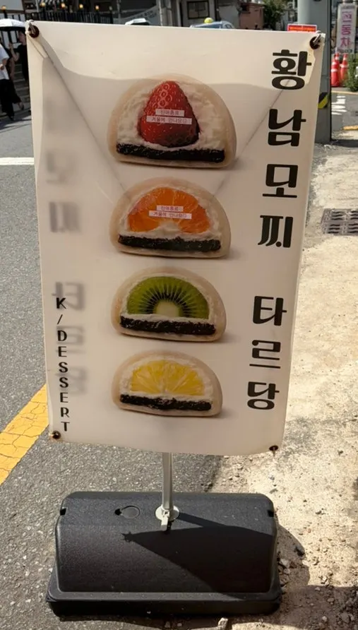 Tareudang sandwich board displaying photos of mochi