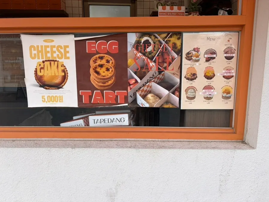 Egg tarts and cheesecake tarts on display at Tareudang